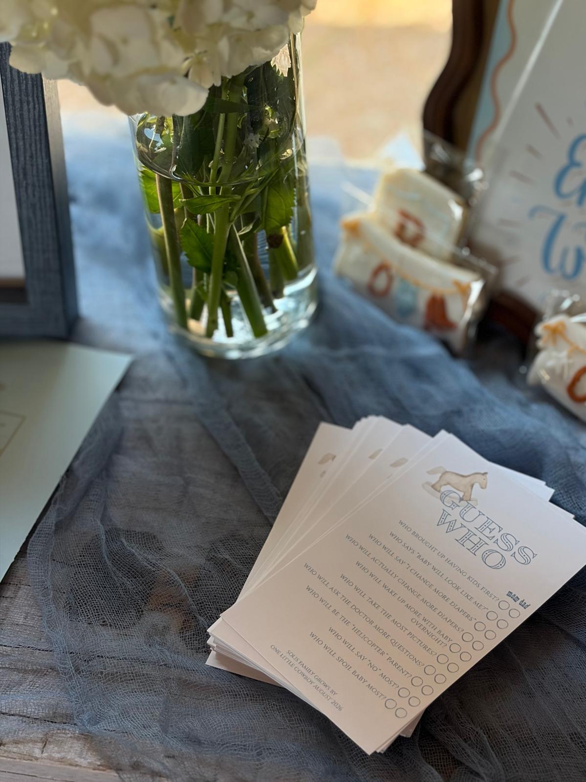 Stack of "Guess Who" baby shower game cards with a rocking horse illustration